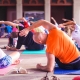 Class of people doing yoga poses on exercise mats