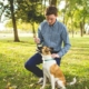 man holding stick in front of a dog