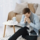 Man sneezing beside his allergy medications in Arkansas home